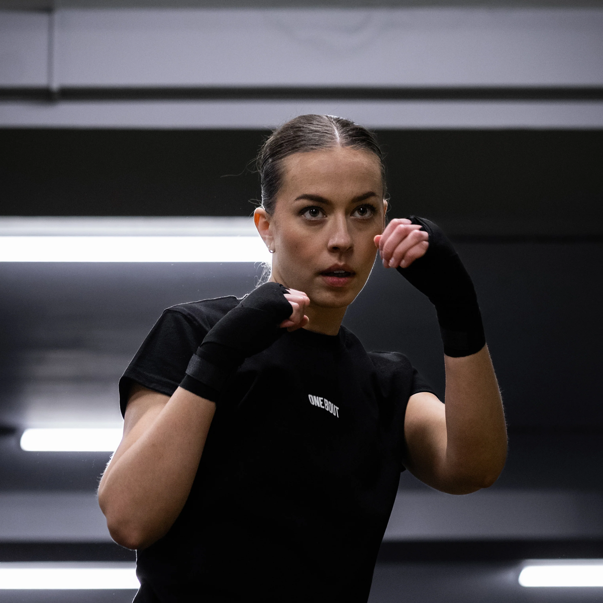 Tereza Netušilová, kickboxer, guard up in a black One Bout tee