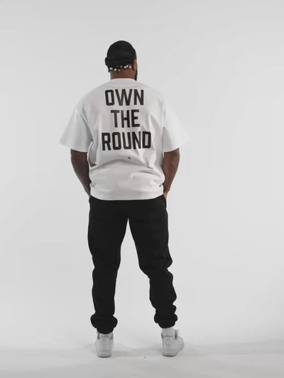 Male model in white ONE BOUT Own The Round oversized t-shirt — fit and movement