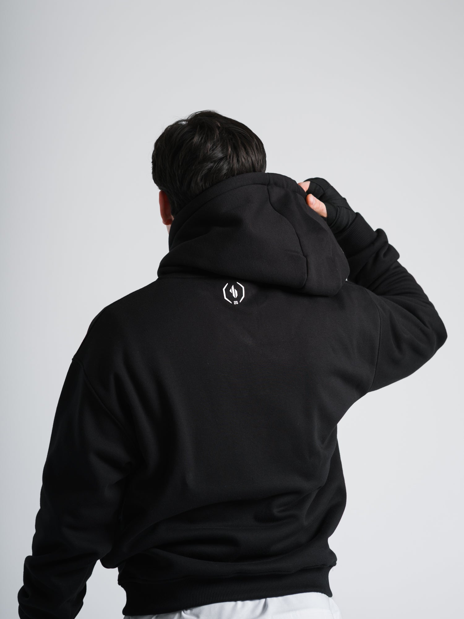Male model wearing black ONE BOUT Script Oversized Hoodie Limited edition
