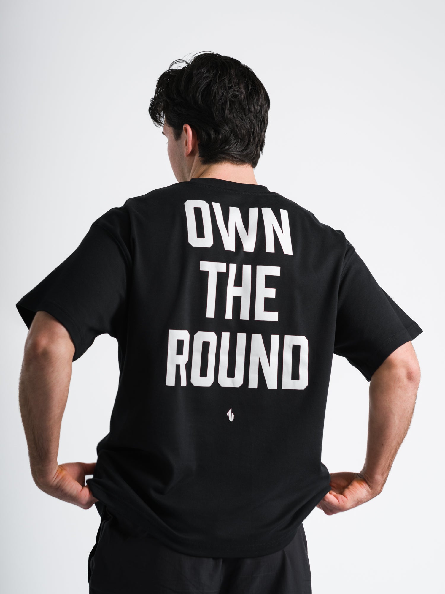 Male model wearing black ONE BOUT OWN THE ROUND Oversized T-Shirt back view