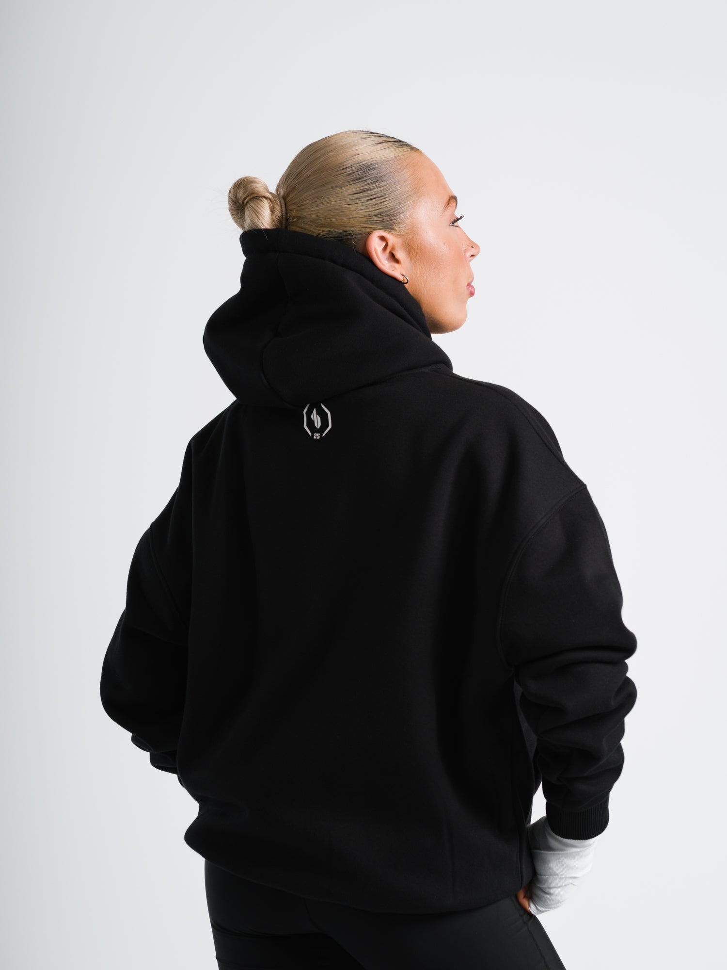Female model wearing black ONE BOUT Script Oversized Hoodie Limited edition