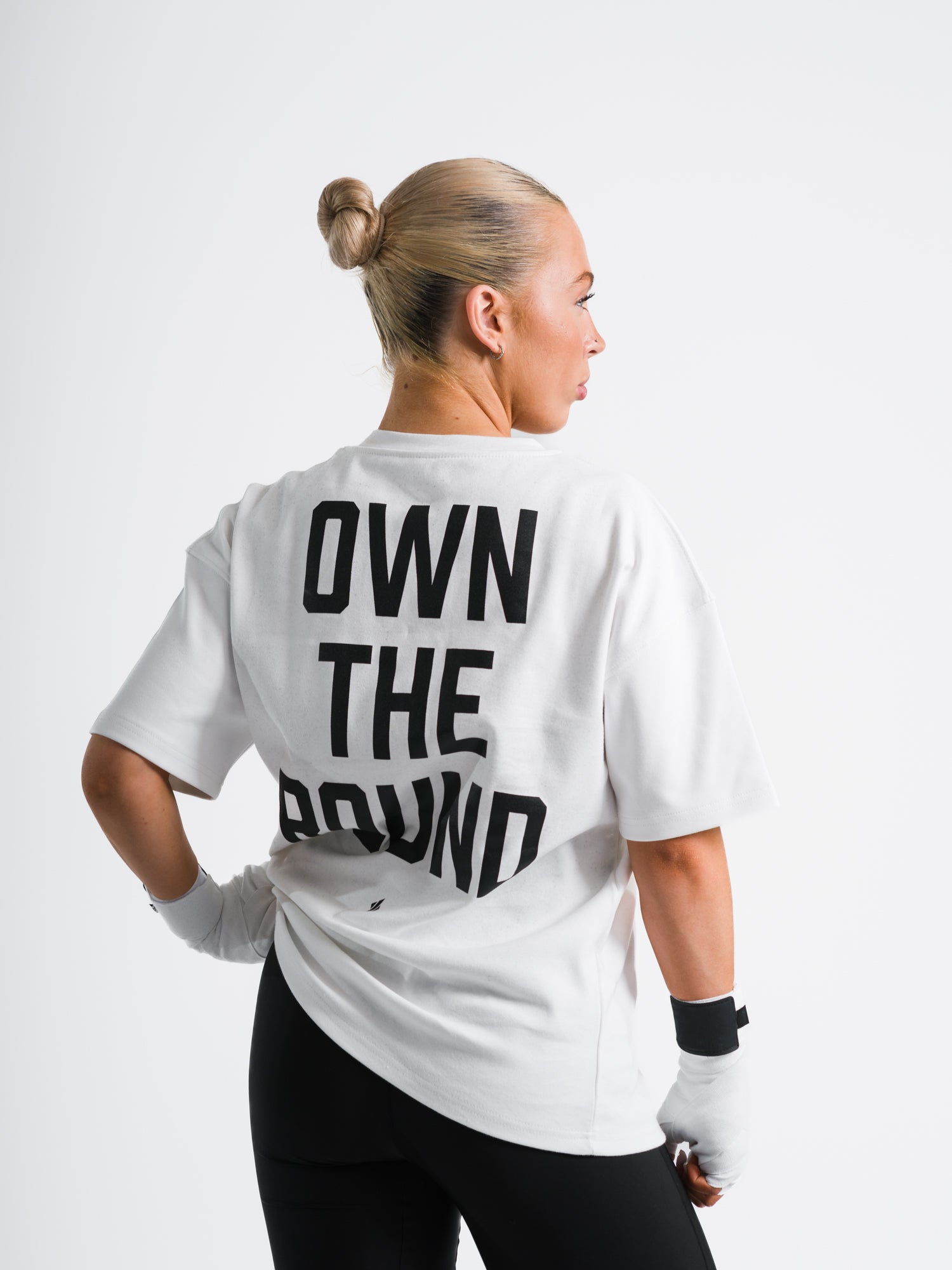 Female model wearing white ONE BOUT OWN THE ROUND Oversized T-Shirt back view